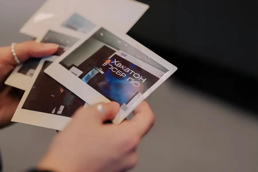 Карточка Полароид с проявляющимся снимком в руках гостя