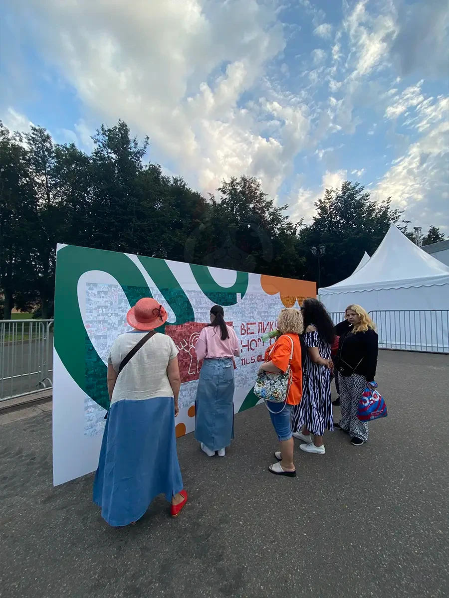 Гости рассматривают фотомозаику на площади Победы-Софийской