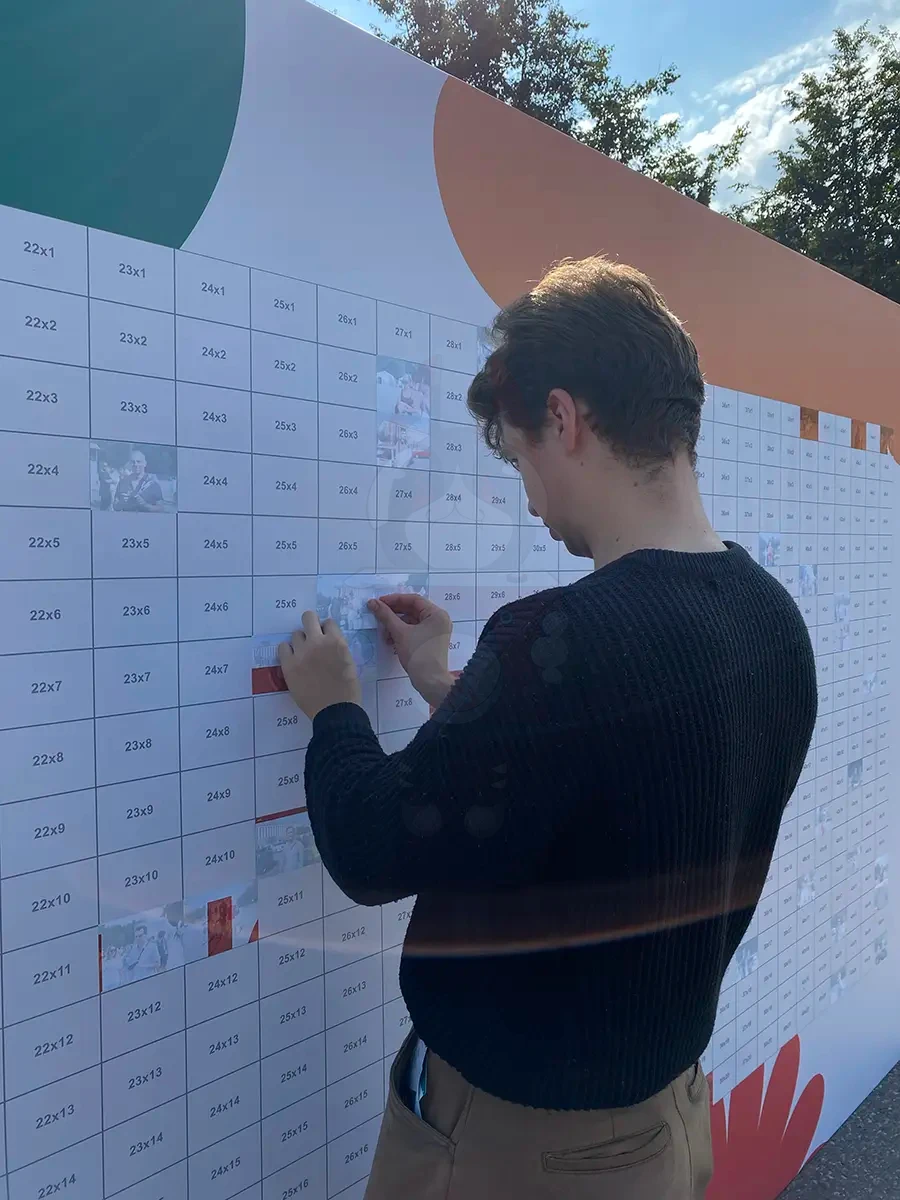 Процесс сборки фотомозаики: размещение снимков в ячейки панно