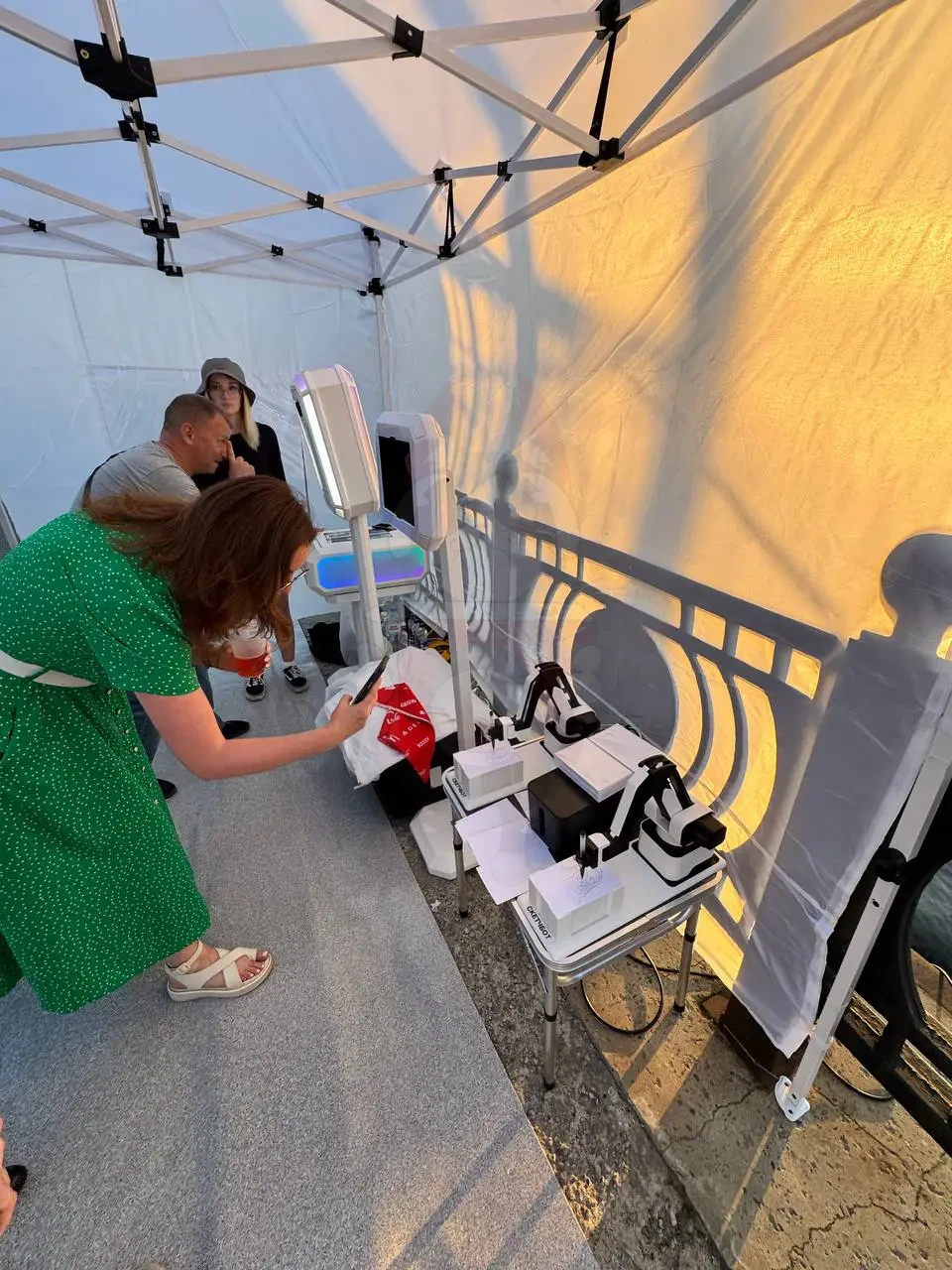 Оператор настраивает фотостойку с нейросетью под шатром на Трудфесте в Архангельске