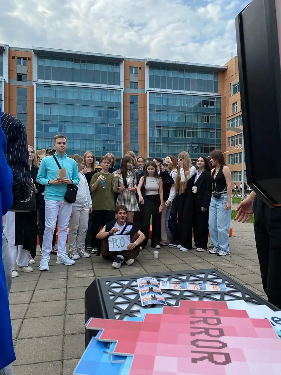 Группа первокурсников у фотобудки MixUp, на столе напечатанные фотополоски